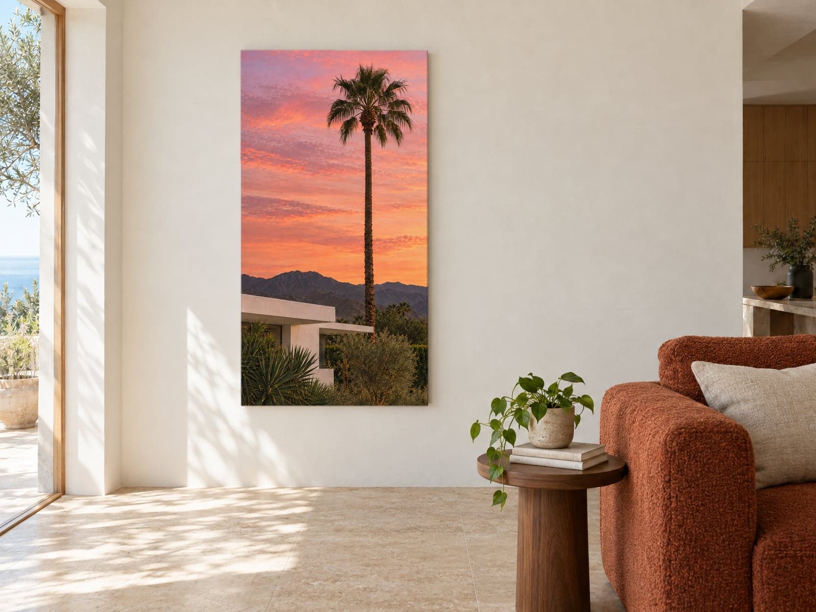 A tall canvas of a palm tree at sunset beside a rust armchair