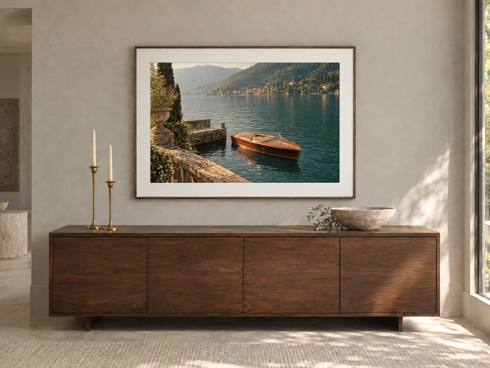 A framed print of a wooden boat on a lake above a walnut sideboard