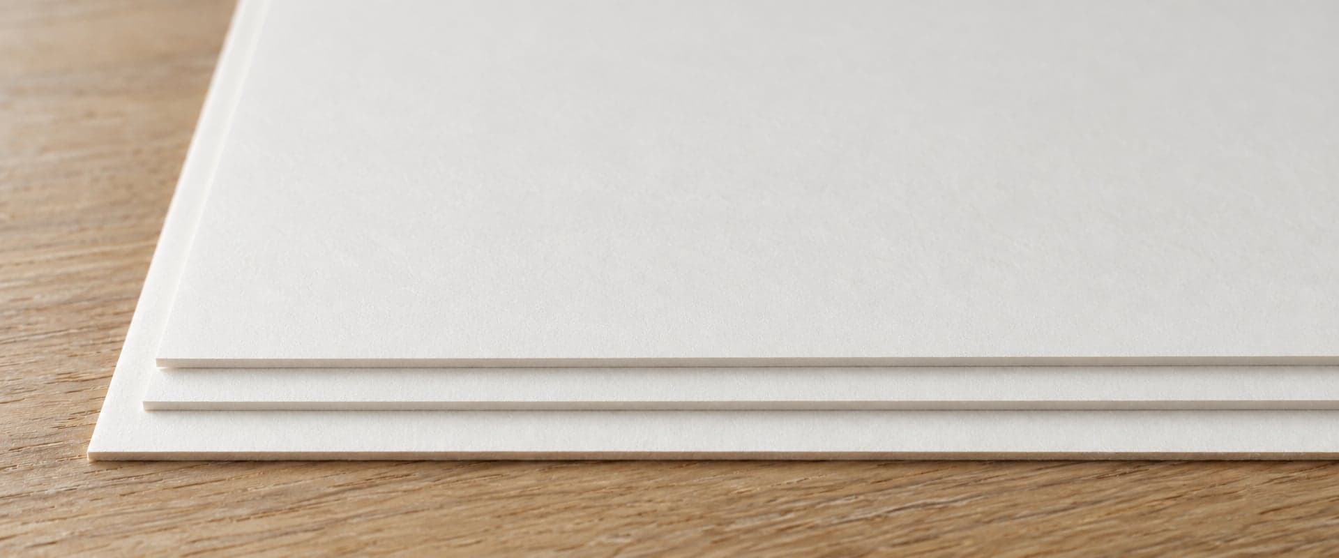 A stack of bright white archival matte paper, close up