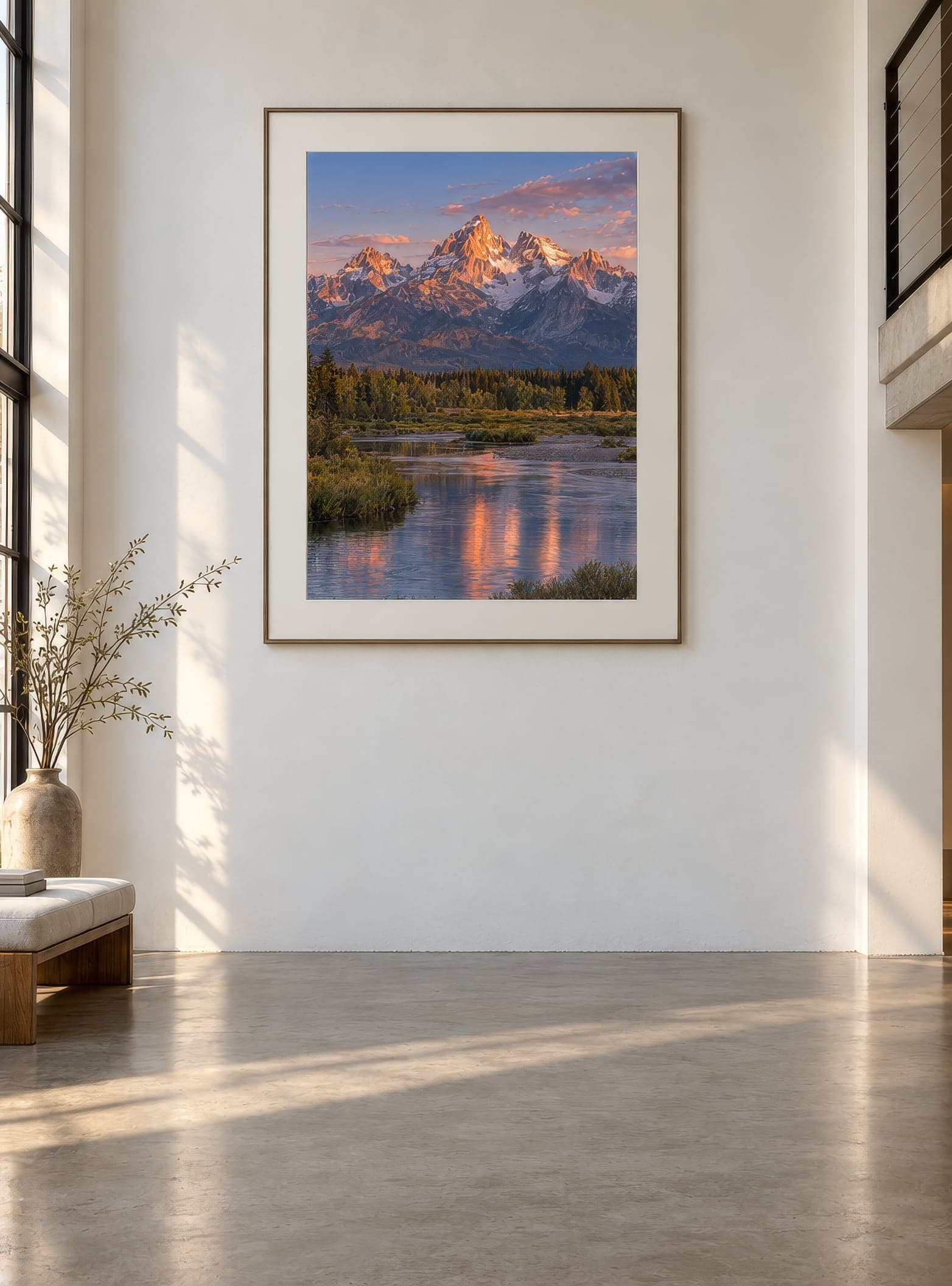A large framed print of mountain peaks at sunrise in a bright living space