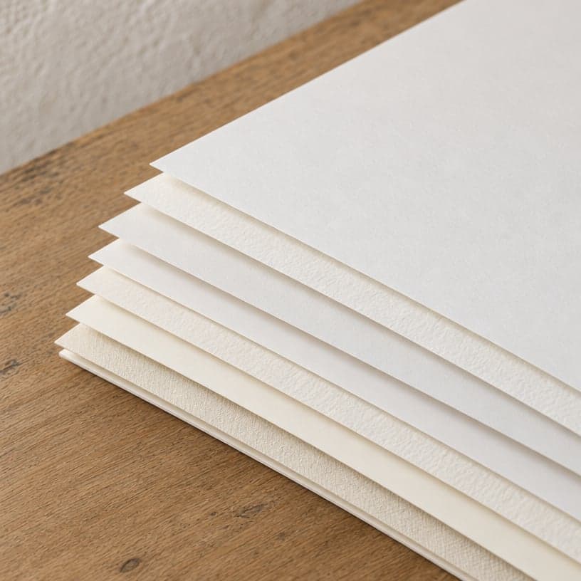 A stack of fine art paper on a wooden table