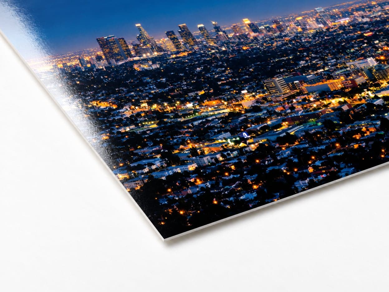 The corner of a glossy photo print of a city at night