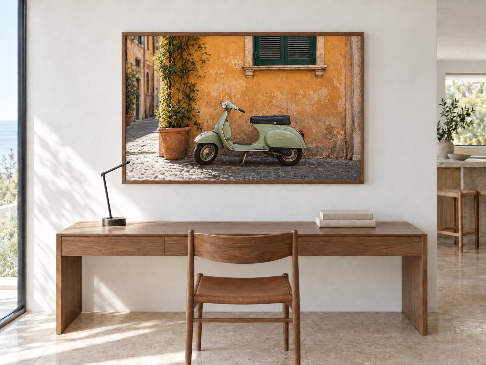 A framed photo of a green scooter by a yellow wall above a writing desk