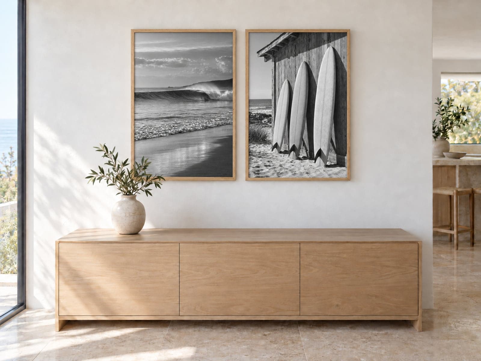 Two framed black and white surf photos above an oak sideboard